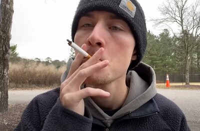 Лечение зависимости от табакокурения в ЮЗАО Москвы Мужчина с сигаретой делает затяжку